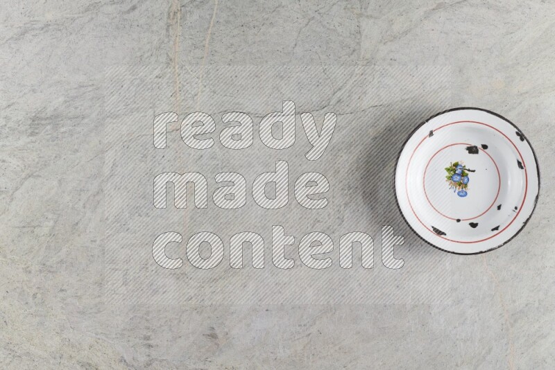 صحن معدني عتيق على خلفية من الرخام الرمادي