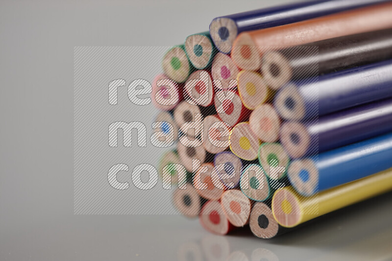 An array of colored pencils on grey background