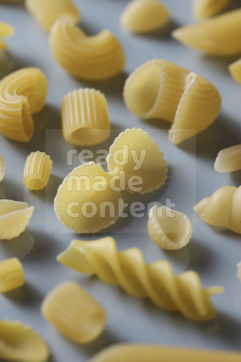 Different pasta types on light blue background