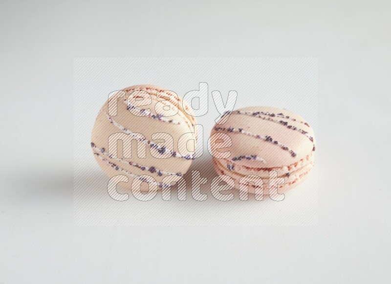 45º Shot of two pink orange blossom macarons on white background