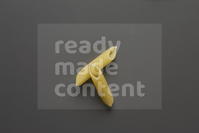 Penne pasta on grey background