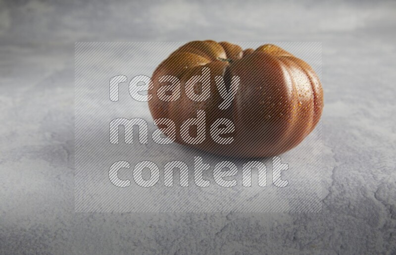 45 degree single heirloom tomato on a light blue textured background