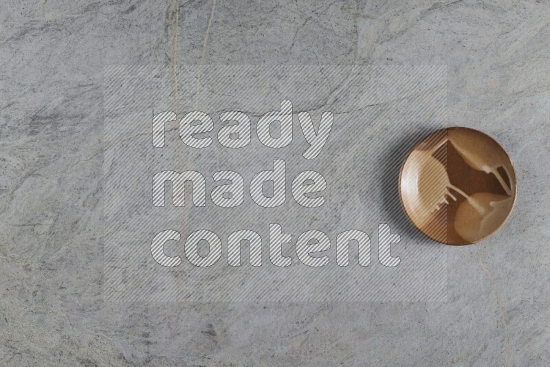 صحن فخاري متعدد الألوان على خلفية من الرخام الرمادي