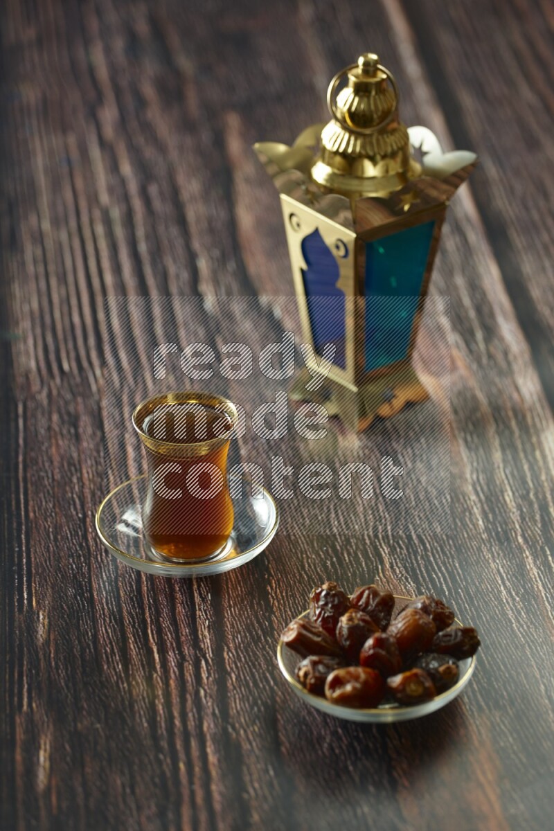 A golden lantern with different drinks, dates, nuts, prayer beads and quran on brown wooden background