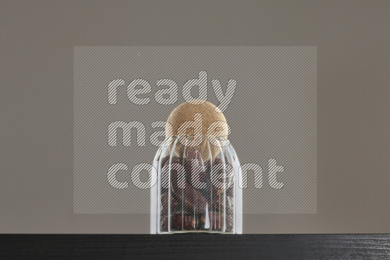 Dates in a glass jar on black background