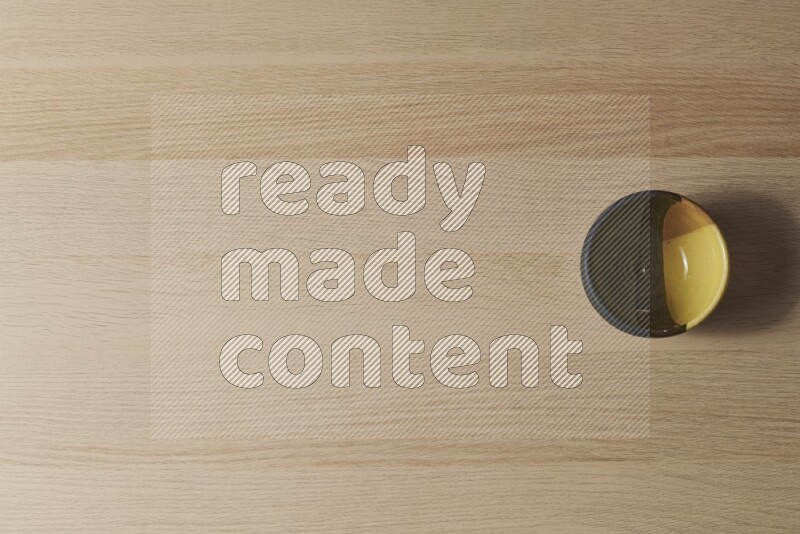 A multicolored pottery bowl on light wooden background