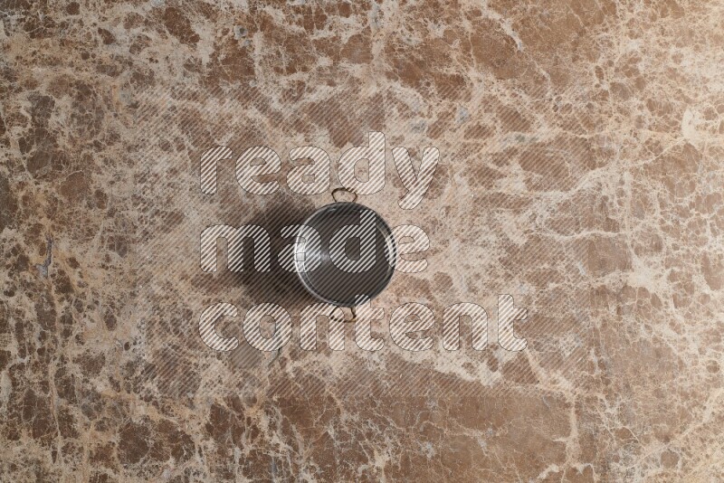 A small copper pot on beige marble background