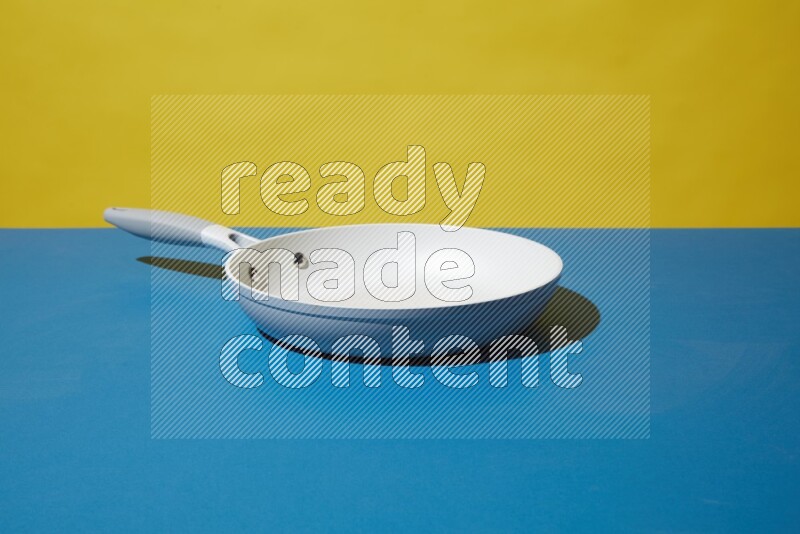 white pan on yellow and Blue background