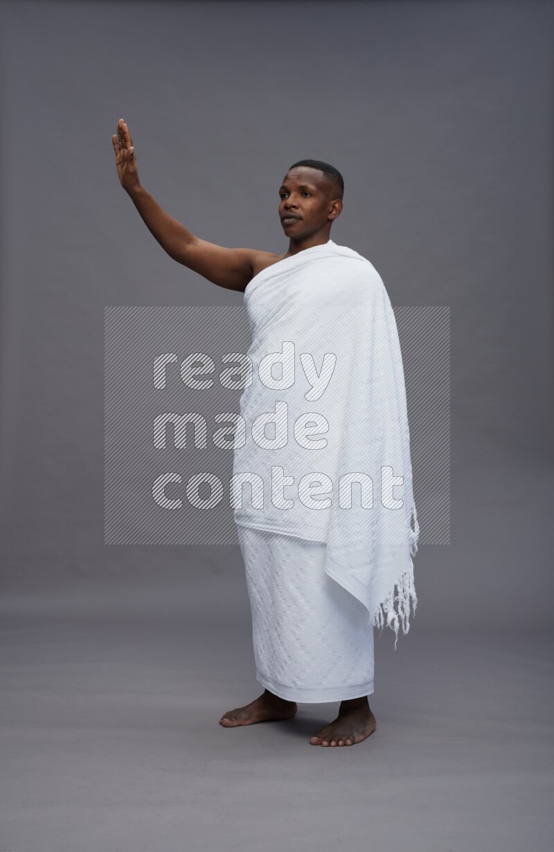 A man wearing Ehram Standing Interacting with the camera on gray background