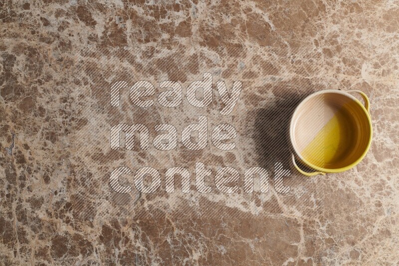 A multicolored pottery bowl on beige marble background