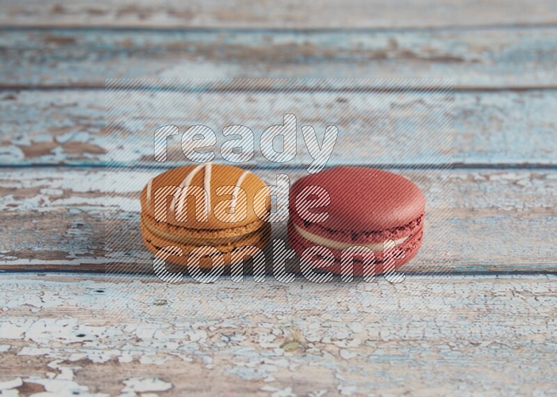 45º Shot of of two assorted Brown Irish Cream, and Red Velvet macarons on light blue background