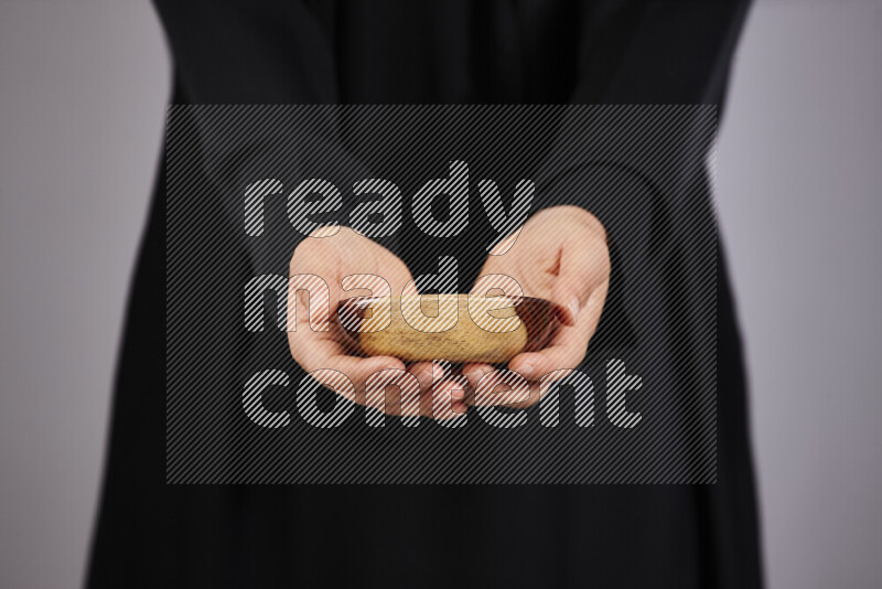 A woman in black abaya holding different wooden essentials in different positions