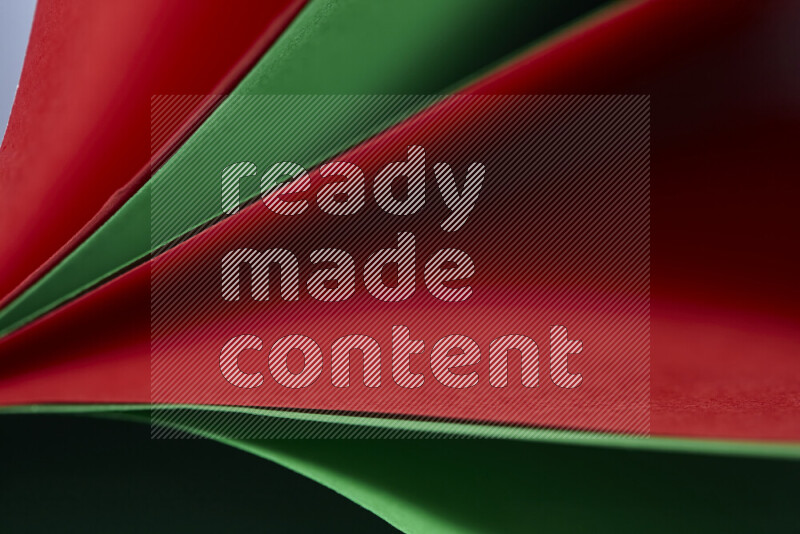 An abstract art showing red and green paper sheets arranged in an overlapping curves