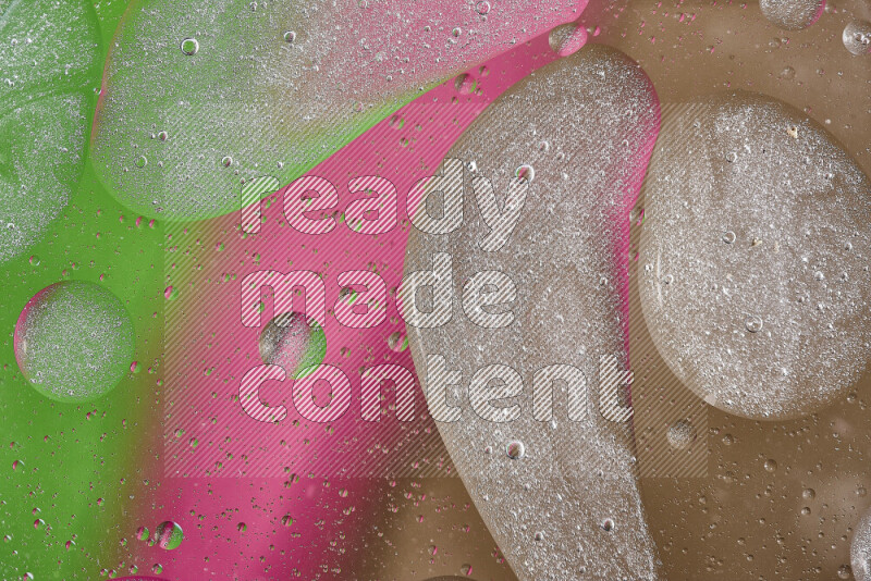 Close-ups of abstract oil bubbles on water surface in shades of brown, green and pink