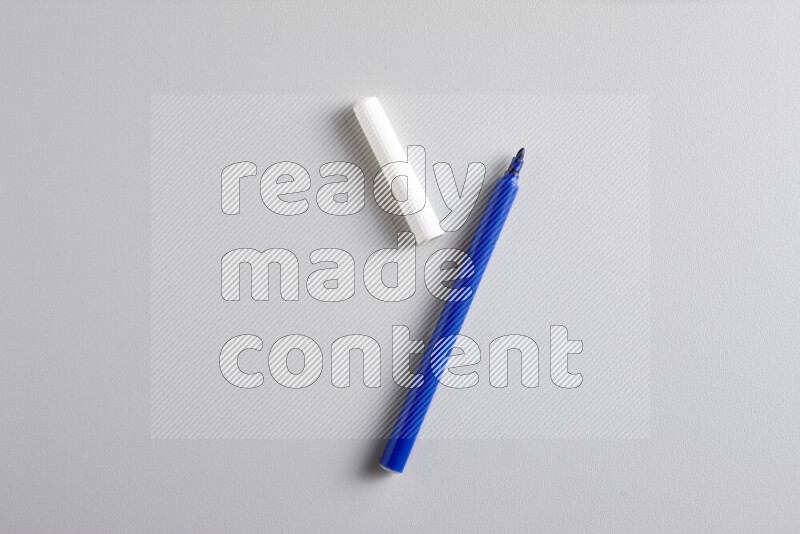 A close-up showing an open single coloring pen with a cap on grey background