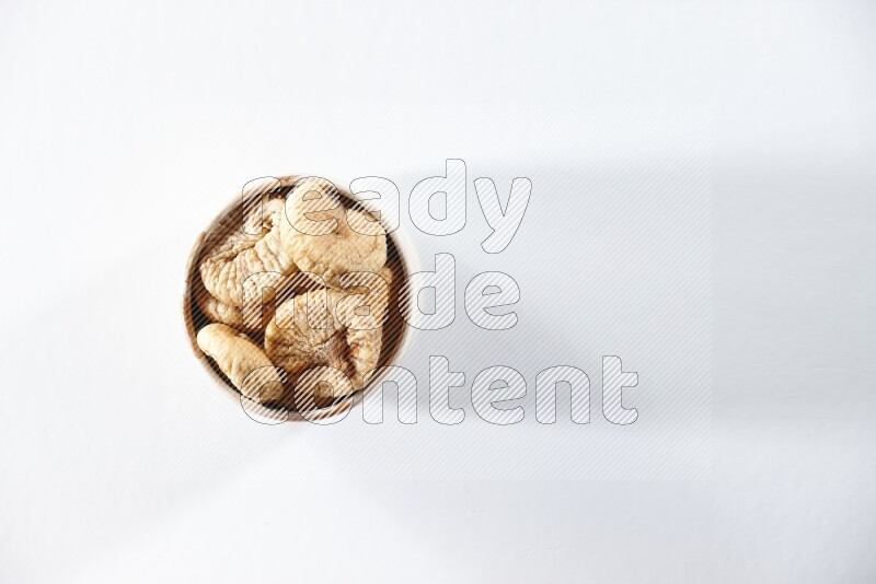 A beige ceramic bowl full of dried figs on a white background in different angles