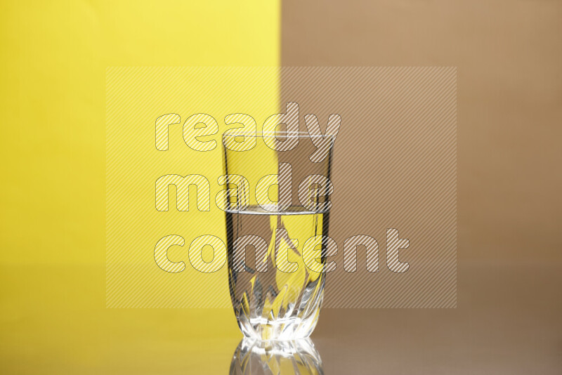 The image features a clear glassware filled with water, set against yellow and beige background