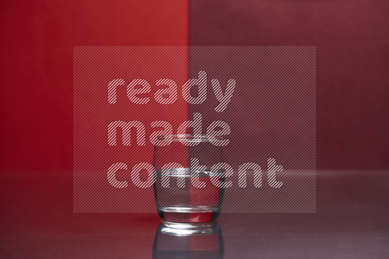 The image features a clear glassware filled with water, set against red and dark red background