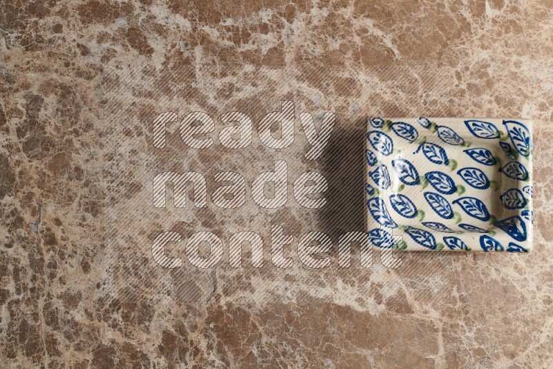 A decorative pottery plate on beige marble background