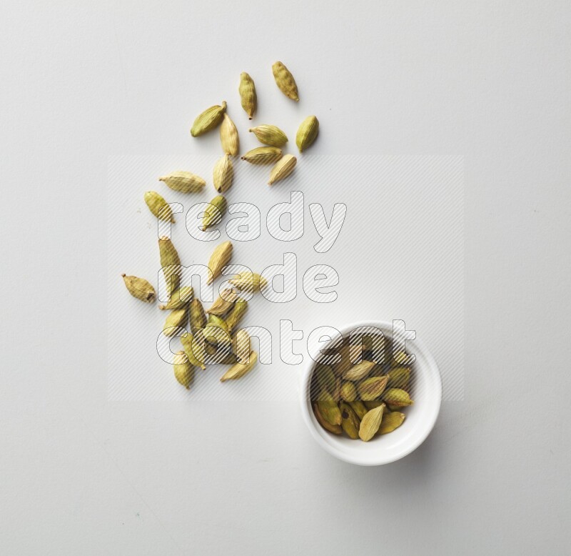 Top-view shot of Cardamon in a container on white background