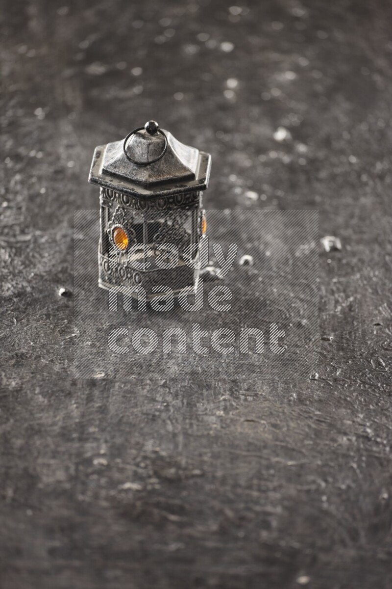 A lantern placed on a textured black background