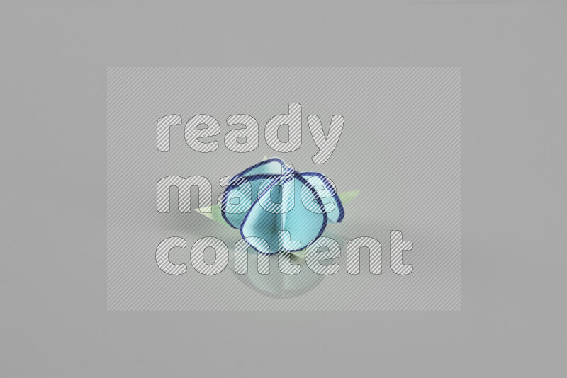 Origami flower on grey background