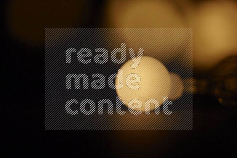 Light bulbs glowing against backdrop of golden bokeh