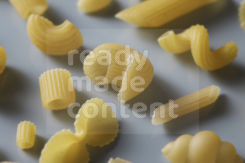 Different pasta types on light blue background