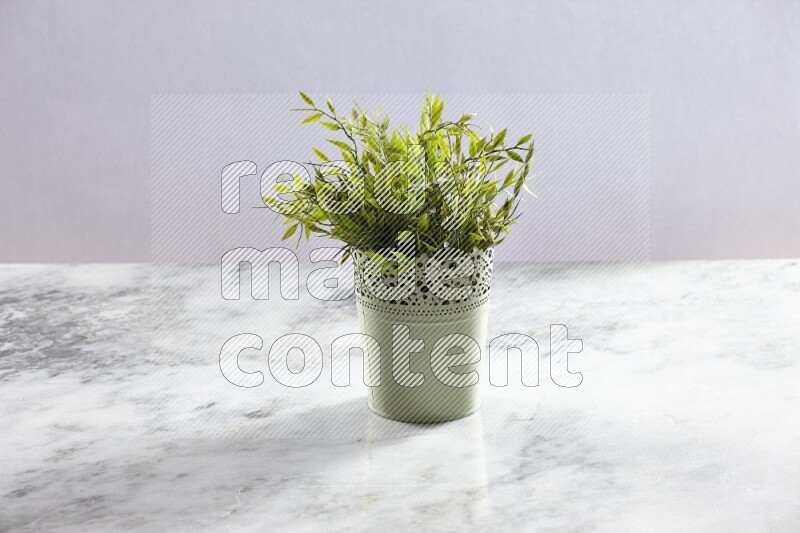 Artificial plant in green decorative pot on grey marble background