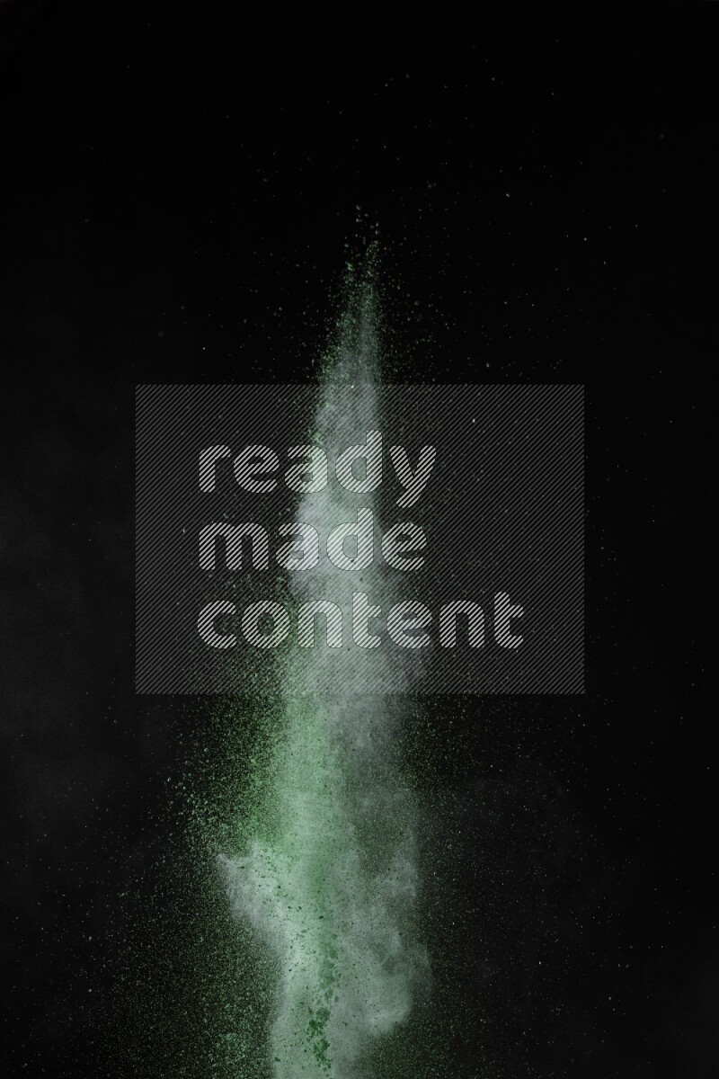 A side view of green powder explosion on black background