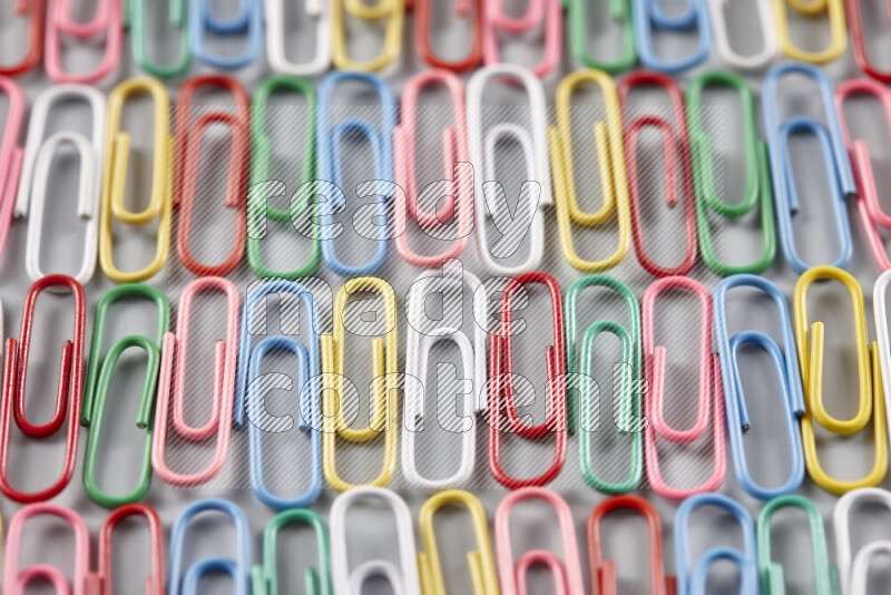 Multicolored paper clips isolated on a grey background