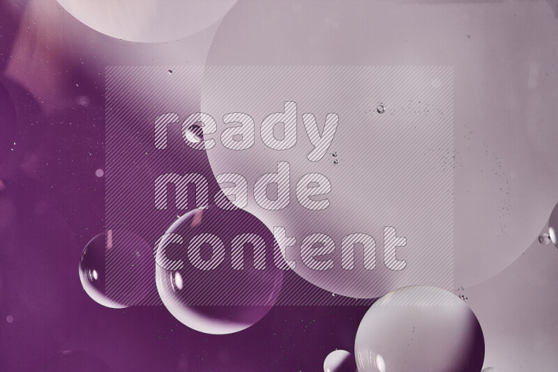 Close-ups of abstract oil bubbles on water surface in shades of white and purple