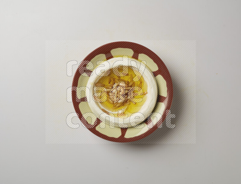 Lebnah garnished with pine nuts in a traditional plate on a white background