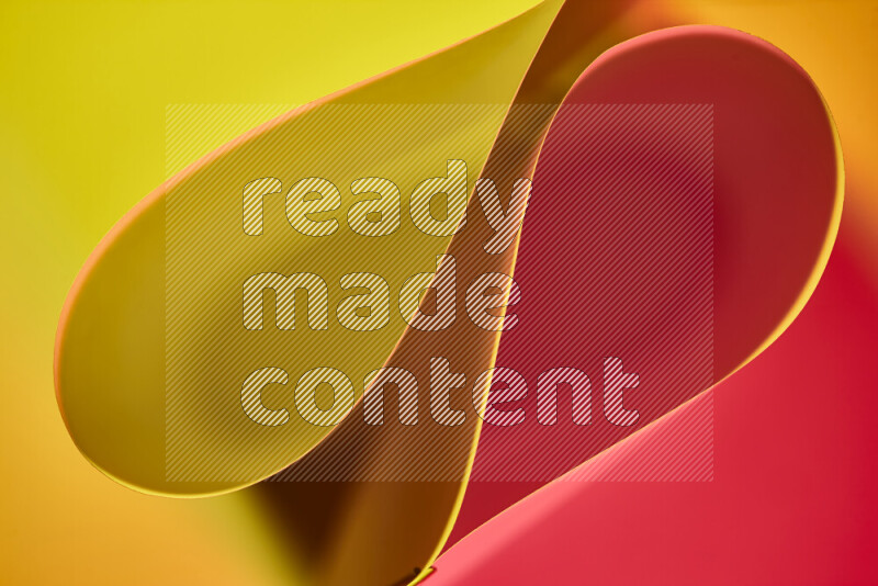 An abstract art of paper folded into smooth curves in yellow and red gradients