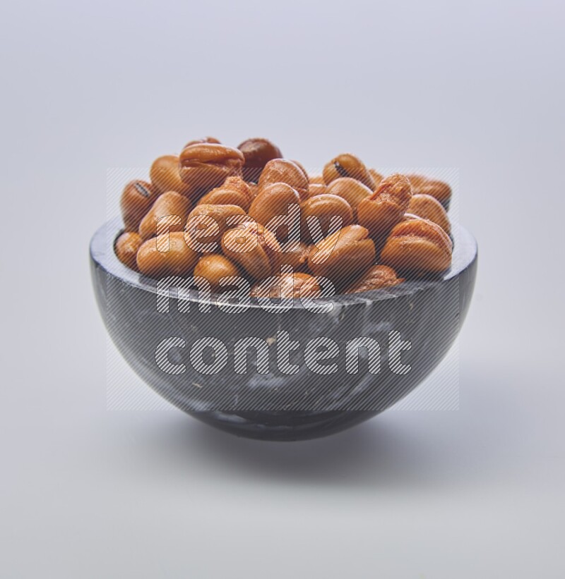Close up shot of cooked fava beans (foul) in a container on white background