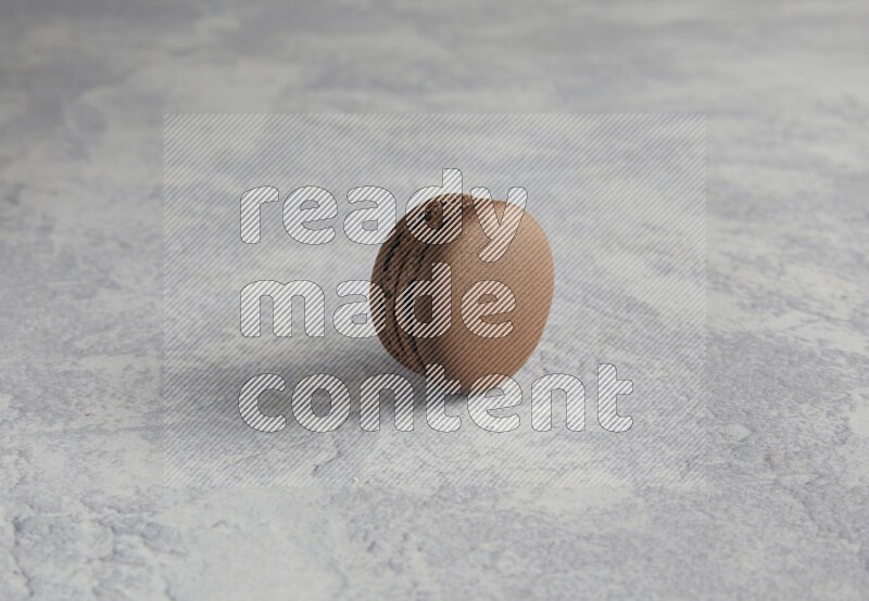 45º Shot of Brown Dark Chocolate macaron on white  marble background
