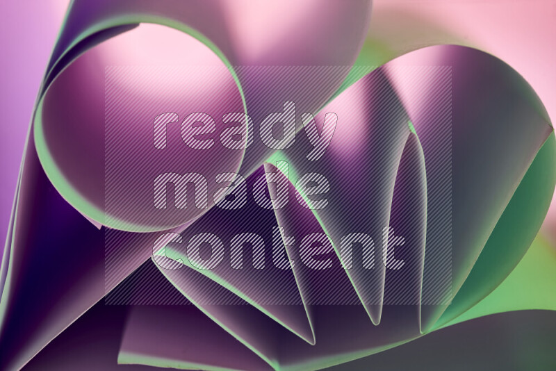 An artistic display of paper folds creating a harmonious blend of geometric shapes, highlighted by soft lighting in green and purple tones
