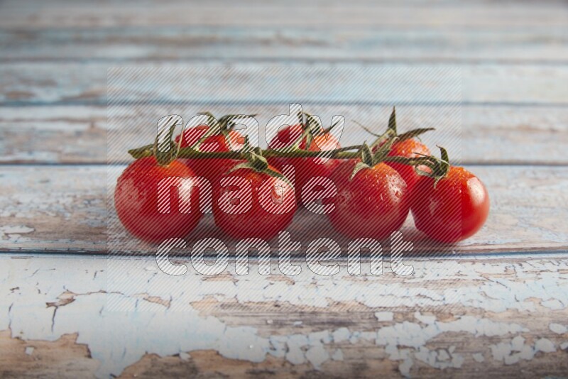 Red cherry tomato vein on a textured blue wooden background 45 degree