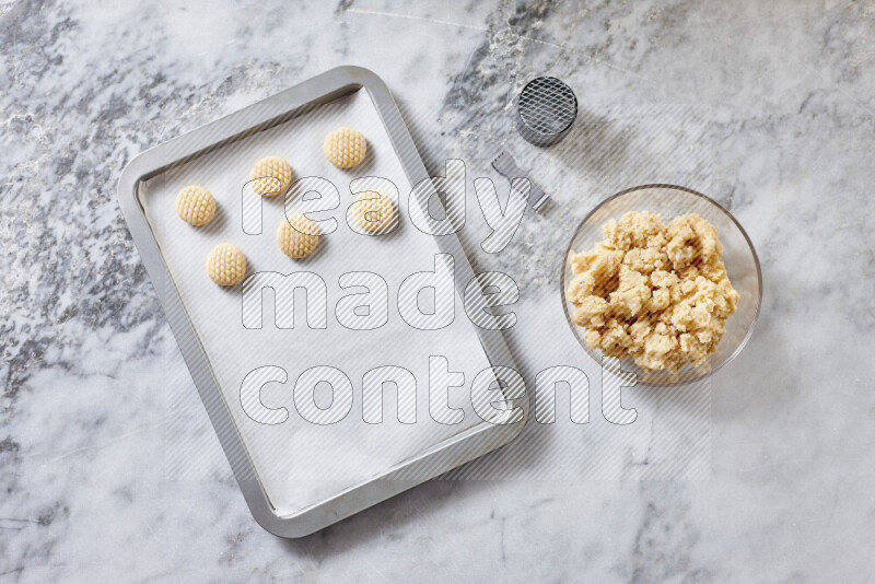 Kahk step by step with its ingredients ghee, sugar, flour, sesame, yeast, water and kahk flavor on grey marble background