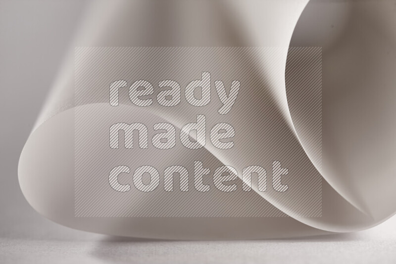 An abstract art piece displaying smooth curves in grey gradients created by colored light