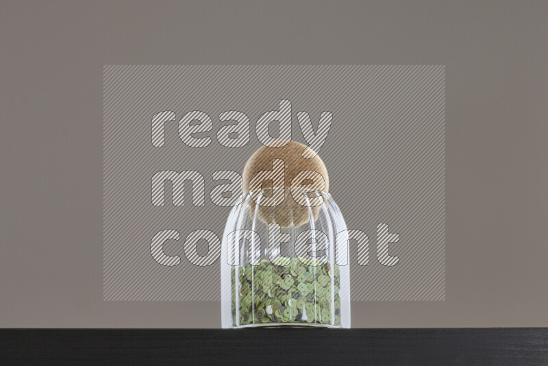 Sequins in a glass jar on black background