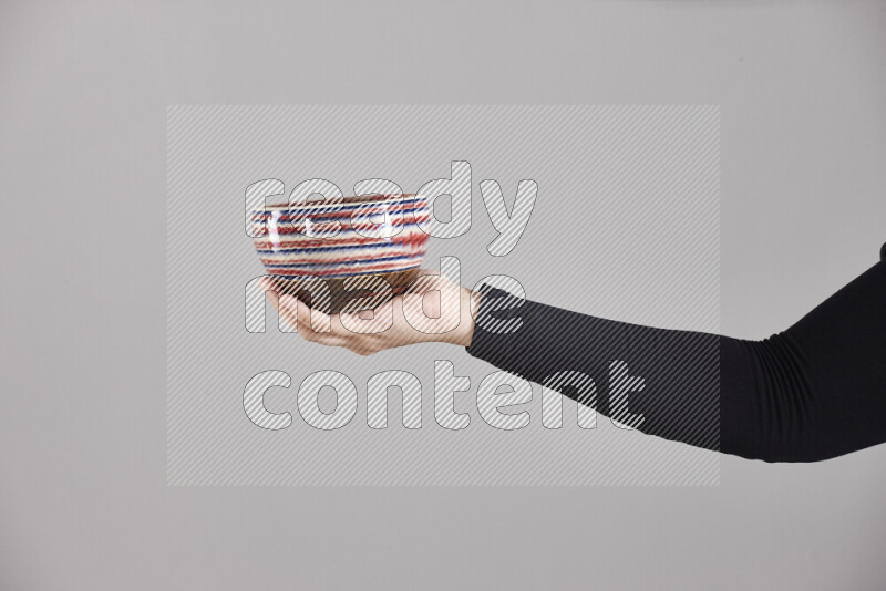 A woman in black abaya holding different pottery essentials in different positions