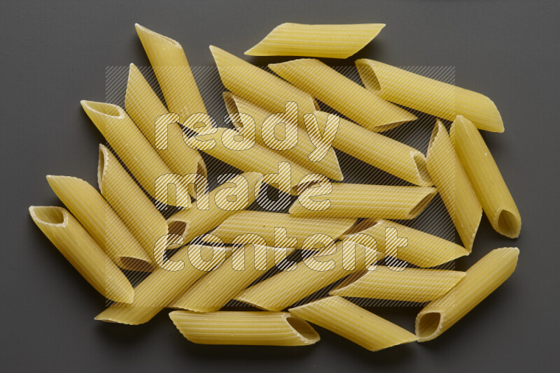 Penne pasta on grey background