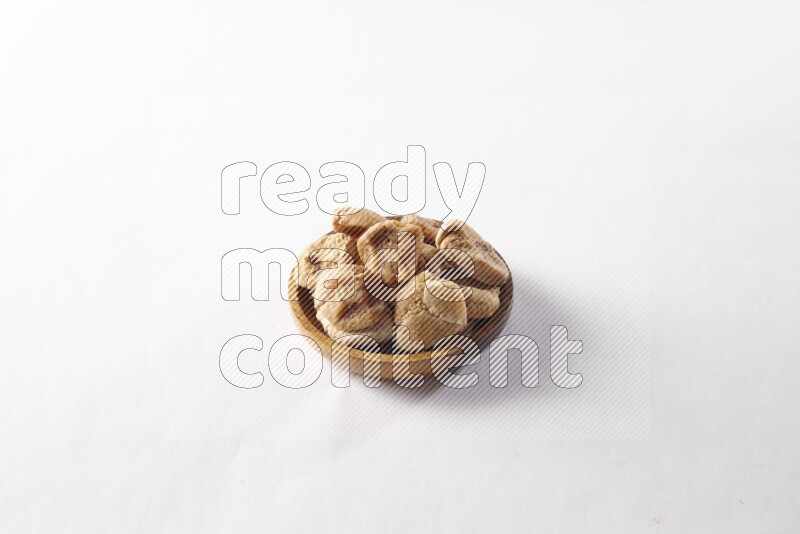 Dried figs in a wooden bowl on white background