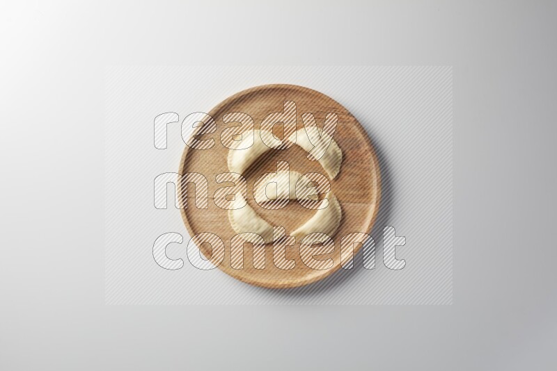 Five Sambosas on a wooden round plate on a white background