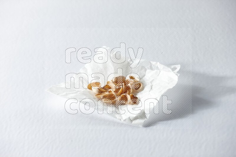 Pistachio peels on a crumpled piece of paper on a white background in different angles