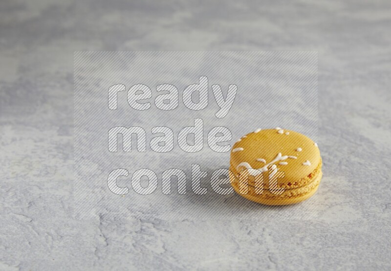 45º Shot of Yellow Piña Colada macaron on white  marble background