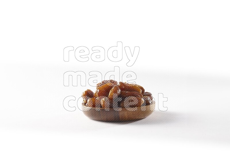 Dates in a wooden bowl on white background