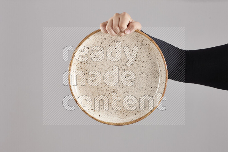 A woman in black abaya holding different pottery essentials in different positions