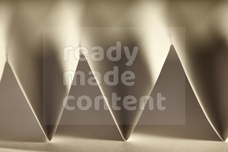 A close-up abstract image showing sharp geometric paper folds in warm gradients